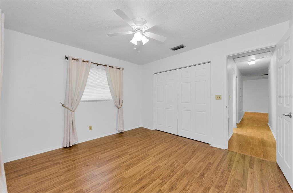 2836 Highlands Boulevard, Unit A Palm Harbor, FL 34684 - Photo 26 of 95 a view of empty room with wooden floor and fan