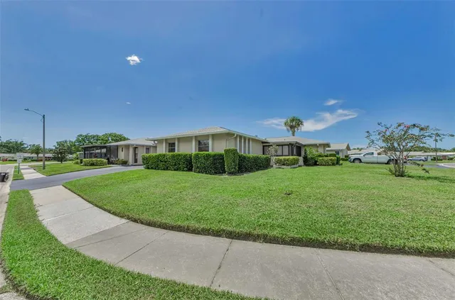a view of a house with a big yard and large trees