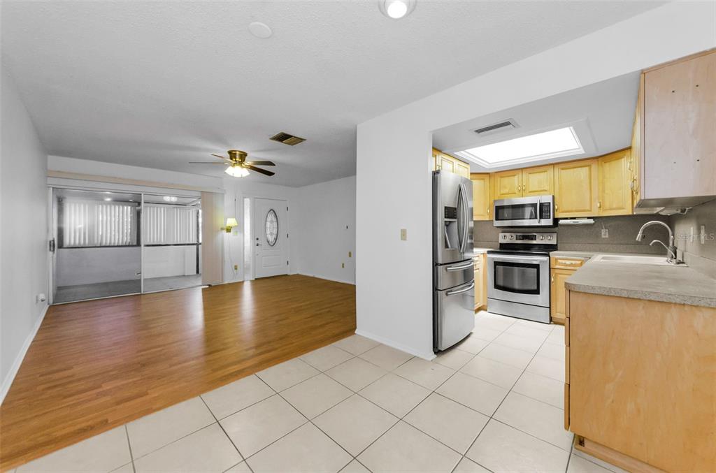 2836 Highlands Boulevard, Unit A Palm Harbor, FL 34684 - Photo 10 of 95 a kitchen with stainless steel appliances granite countertop a refrigerator a stove and a sink with wooden floor