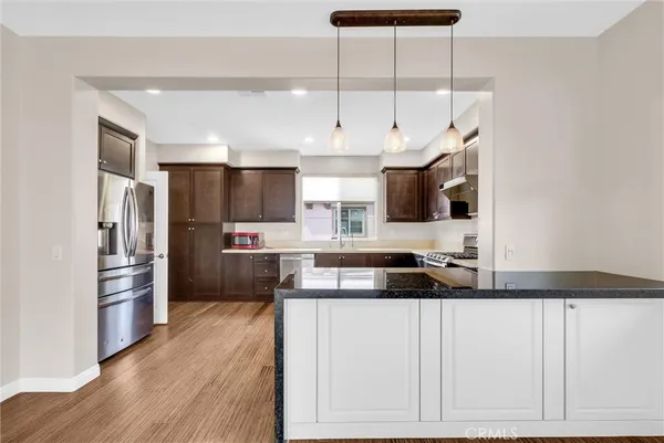a kitchen with granite countertop a refrigerator and a sink