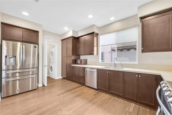 a kitchen with stainless steel appliances granite countertop a refrigerator a sink and wooden cabinets