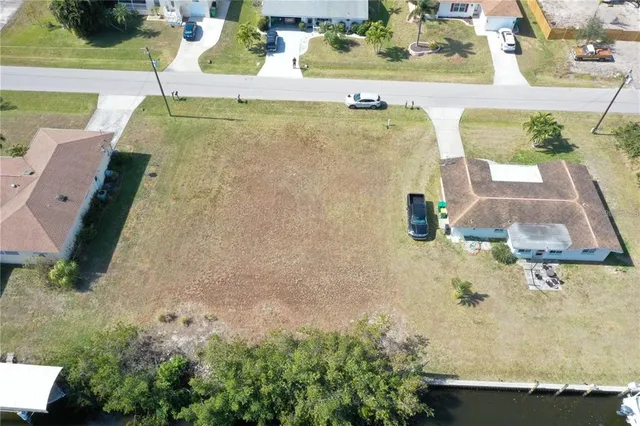 an aerial view of residential houses with outdoor space and parking