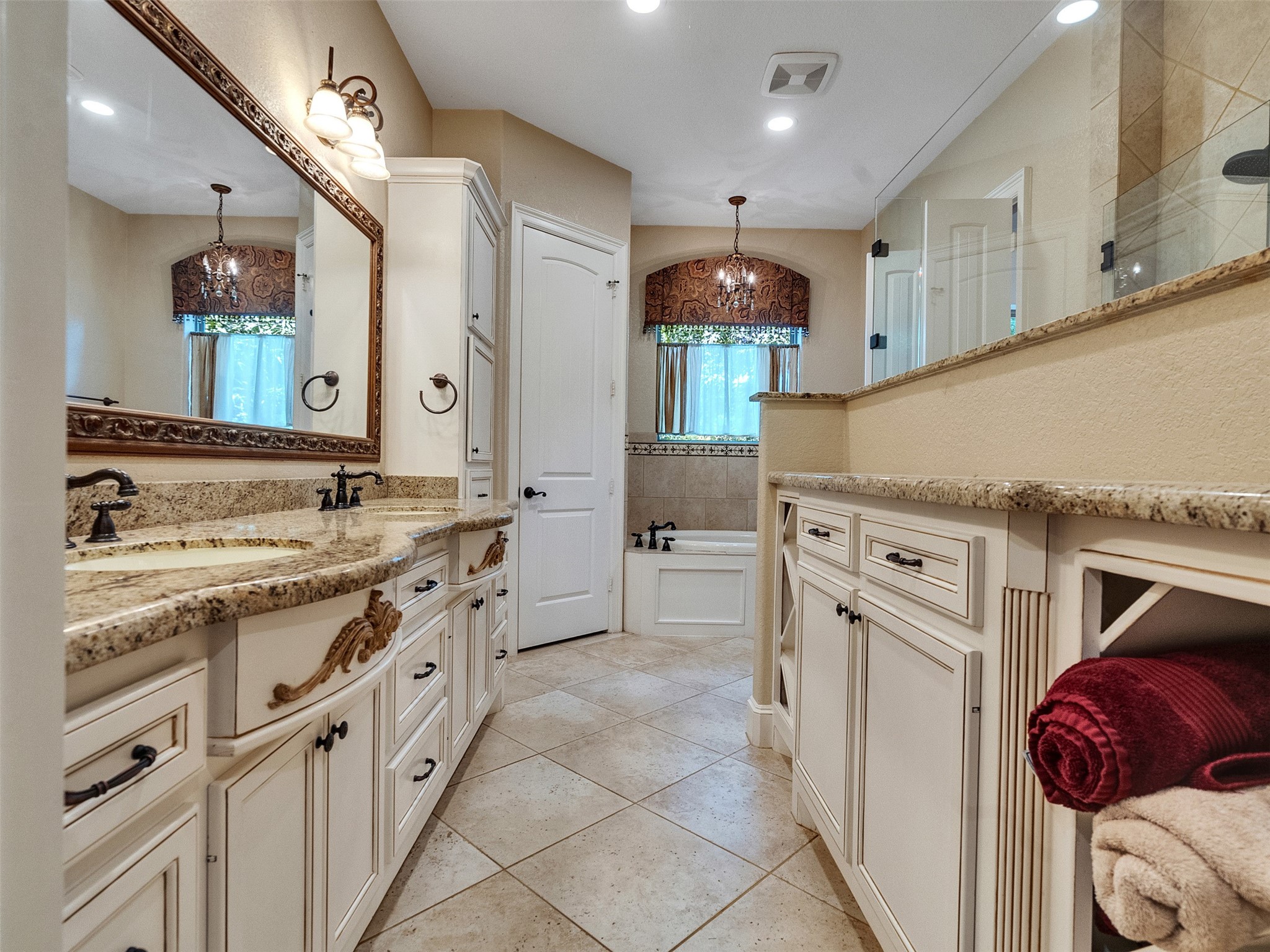 28503 Champions Ridge Road Magnolia, TX 77354 - Photo 18 of 47 The luxurious primary bathroom features a soaking tub, separate shower, dual vanities, and elegant finishes for a spa-like experience.