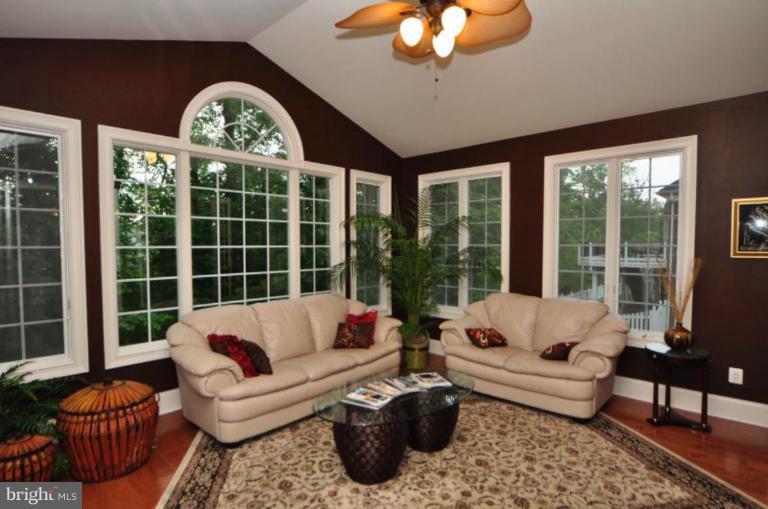 20129 Black Diamond Place Ashburn, VA 20147 - Photo 2 of 20 a living room with furniture a chandelier and a large window