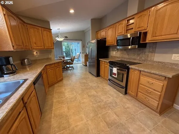 a kitchen with stainless steel appliances granite countertop a stove a sink a microwave and refrigerator