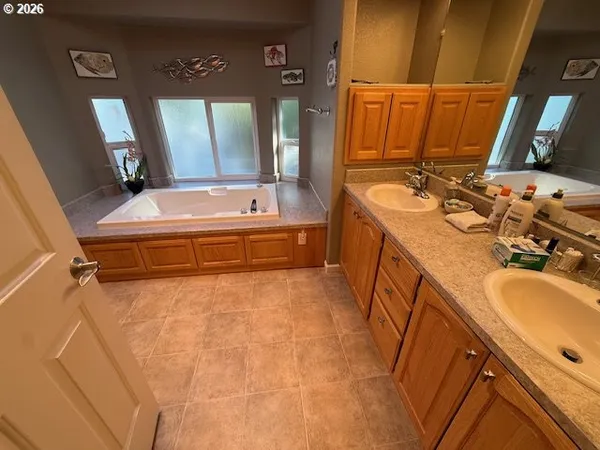 a bathroom with a tub sink and mirror