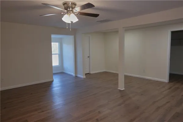 a view of an empty room with wooden floor