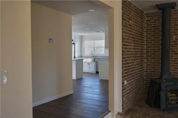 a view of a hallway with wooden floor and a bathroom