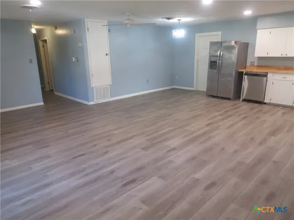 a kitchen with granite countertop a refrigerator sink and cabinets