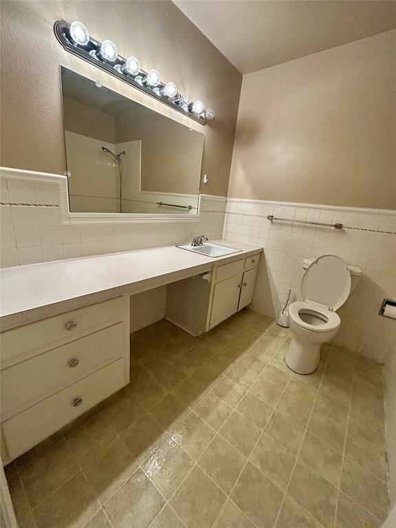 406 Northwest 5th Street Hubbard, TX 76648 - Photo 11 of 40 a spacious bathroom with a double vanity sink a toilet and a mirror