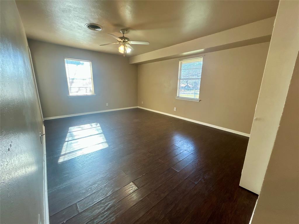 406 Northwest 5th Street Hubbard, TX 76648 - Photo 14 of 40 an empty room with wooden floor and windows