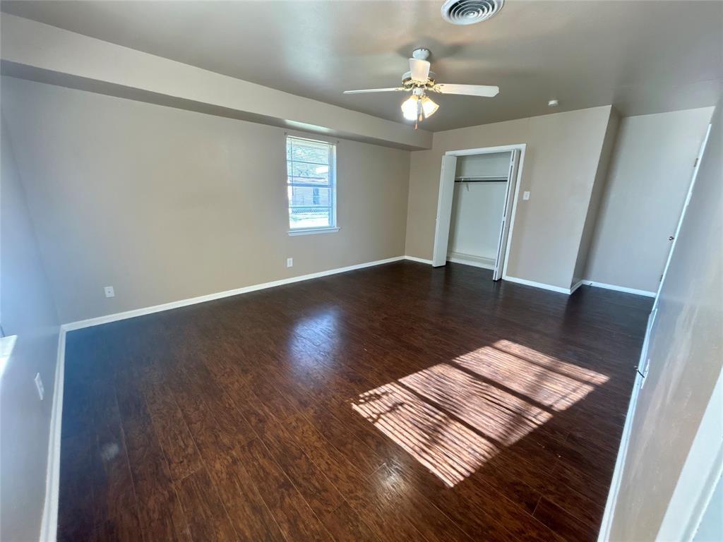 406 Northwest 5th Street Hubbard, TX 76648 - Photo 15 of 40 an empty room with wooden floor fan and windows