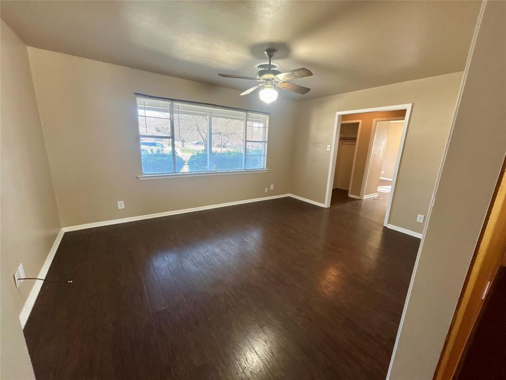 406 Northwest 5th Street Hubbard, TX 76648 - Photo 8 of 40 a view of an empty room with wooden floor and a window