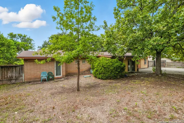 a view of a house with backyard and trees
