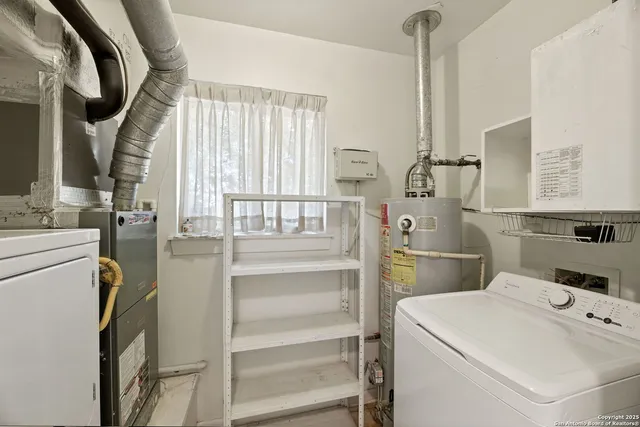 a view of washer and dryer with bathroom in the background