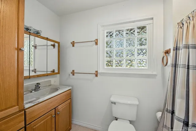 a bathroom with a toilet sink shower and mirror