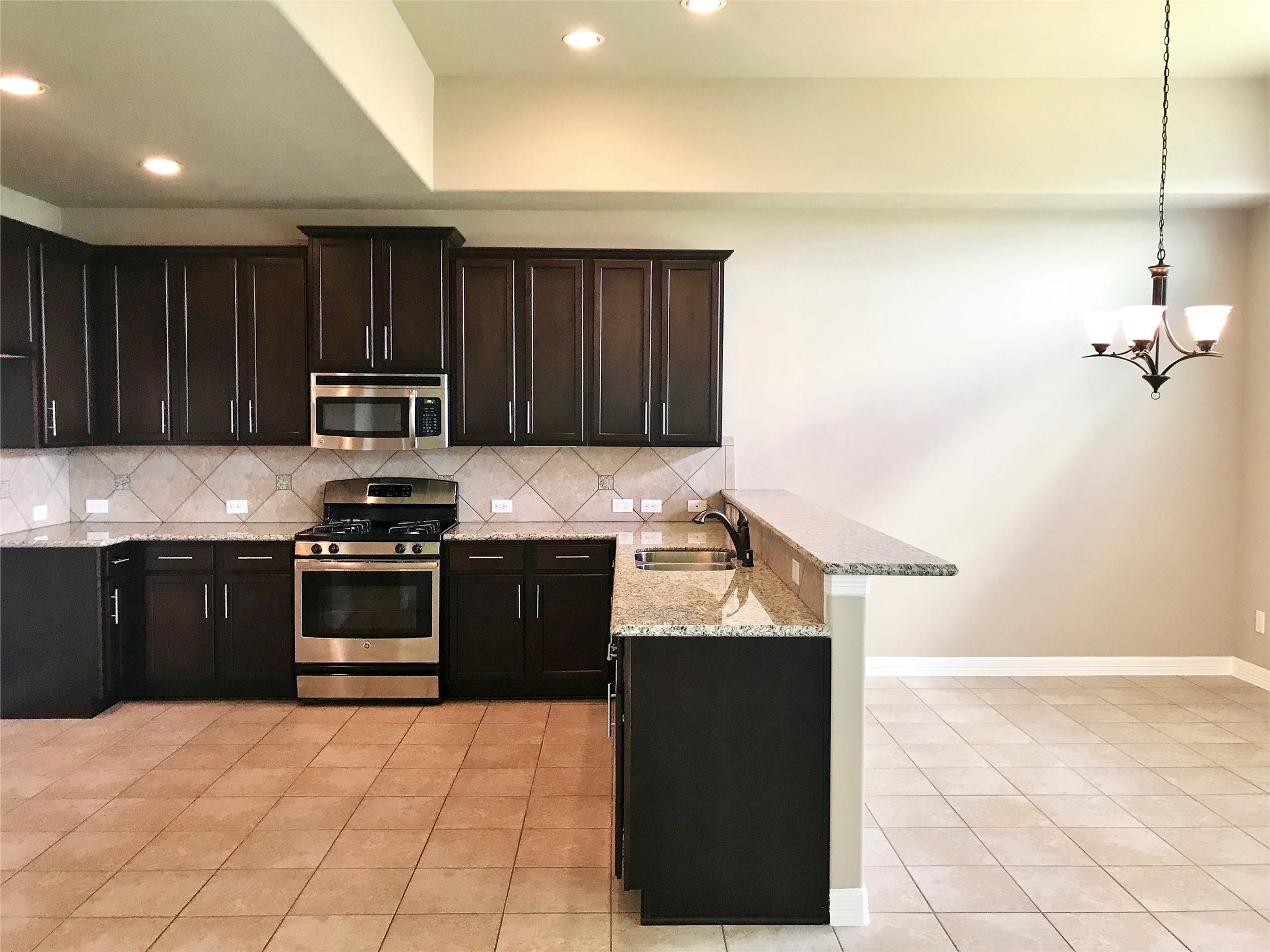 722 Audra Lane Spring, TX 77386 - Photo 4 of 27 a kitchen with granite countertop a stove and a refrigerator