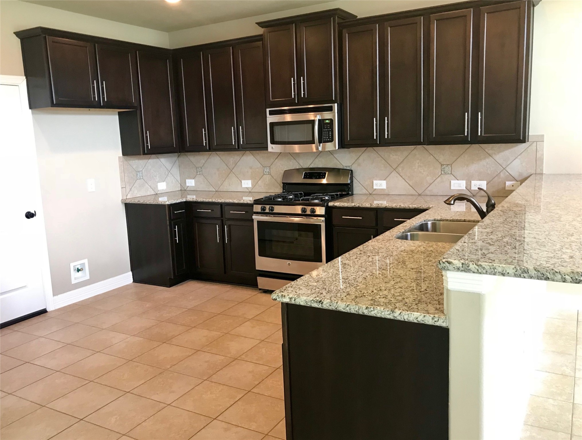 722 Audra Lane Spring, TX 77386 - Photo 6 of 27 a kitchen with granite countertop wood cabinets and stainless steel appliances
