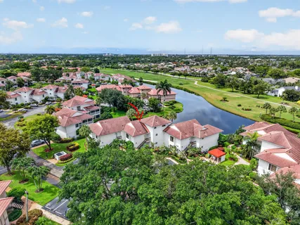 an aerial view of a house with a garden and lake view