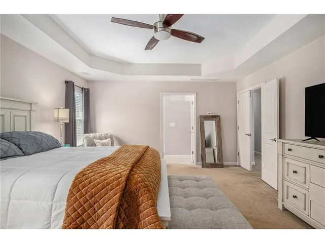 a bedroom with a bed and a flat tv screen on dresser