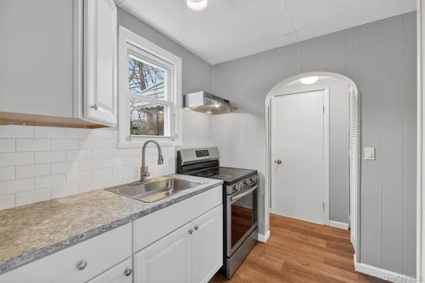 a kitchen with stainless steel appliances granite countertop a sink and wooden floor