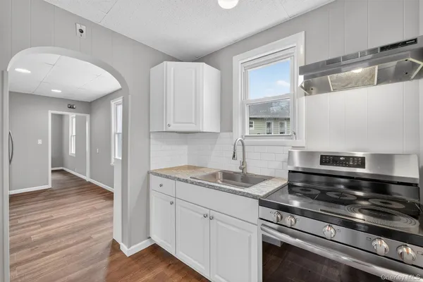 a kitchen with granite countertop cabinets stainless steel appliances and a wooden floor