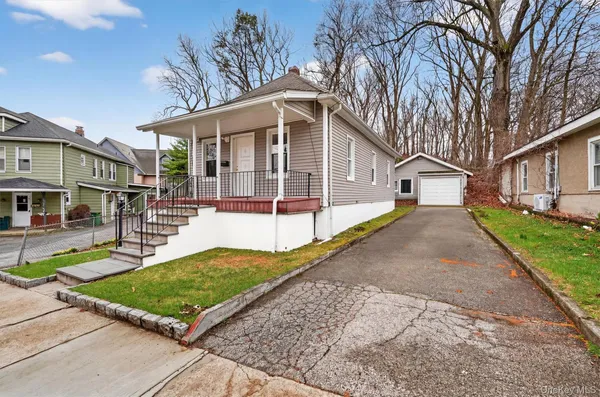 a view of a white house with a yard patio and fire pit