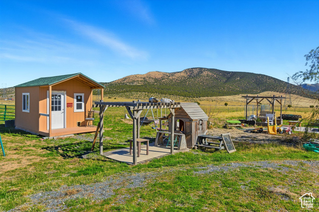 4768 East Hickman Canyon Road Stockton, UT 84071 - Photo 65 of 85 View of playground with a pergola, a rural view, a out building, and a mountain view.