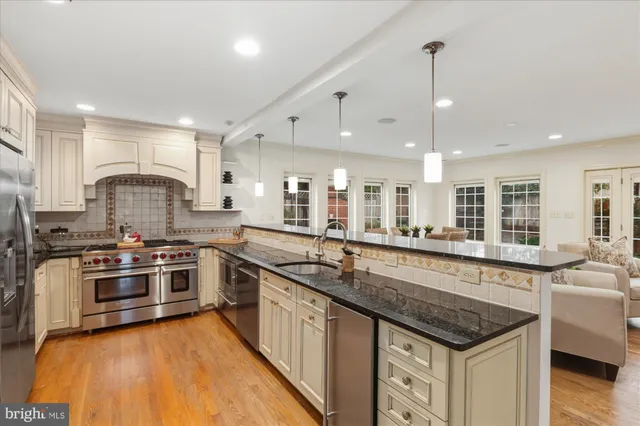 a living room with furniture a fireplace and a dining table with wooden floor