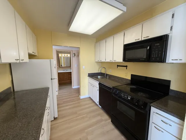 a kitchen with granite countertop a stove and a microwave