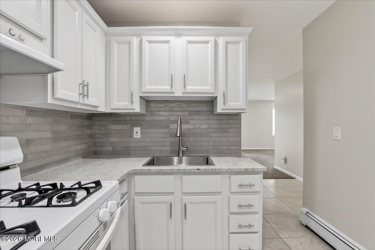 21 Washington Street, Unit D Red Bank, NJ 07701 - Photo 16 of 27 a kitchen with granite countertop a sink a stove and cabinets