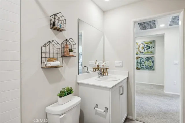 a bathroom with a toilet a sink and mirror