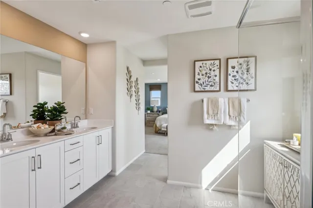 a spacious bathroom with a double vanity sink a mirror and a