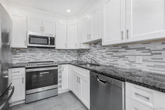 a kitchen with sink cabinets and stainless steel appliances
