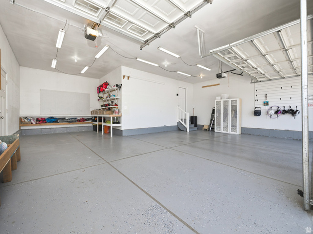 7 Sterling Loop Vineyard, UT 84059 - Photo 7 of 43 Spacious garage featuring a durable epoxy-coated floor, bright overhead fluorescent lighting, and a white interior paint scheme