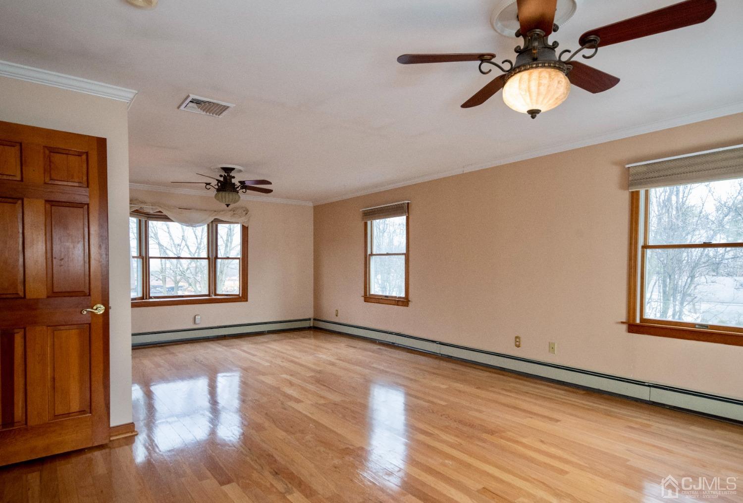 115 New Brooklyn Road Edison, NJ 08817 - Photo 23 of 53 an empty room with wooden floor fan and windows