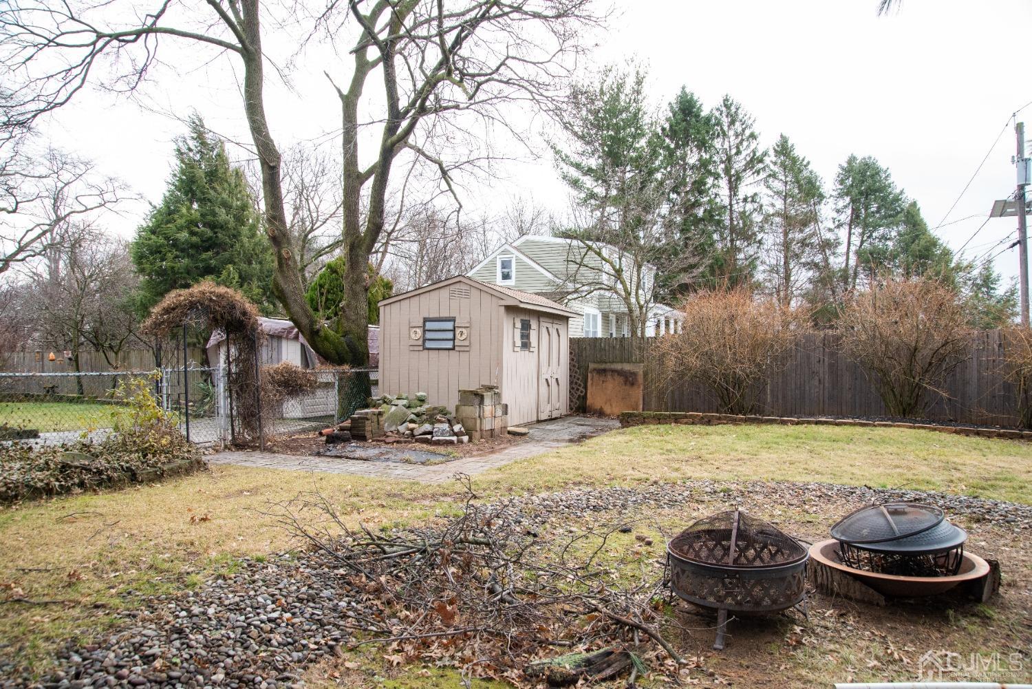 115 New Brooklyn Road Edison, NJ 08817 - Photo 44 of 53 a view of a backyard with table and chairs and a fire pit