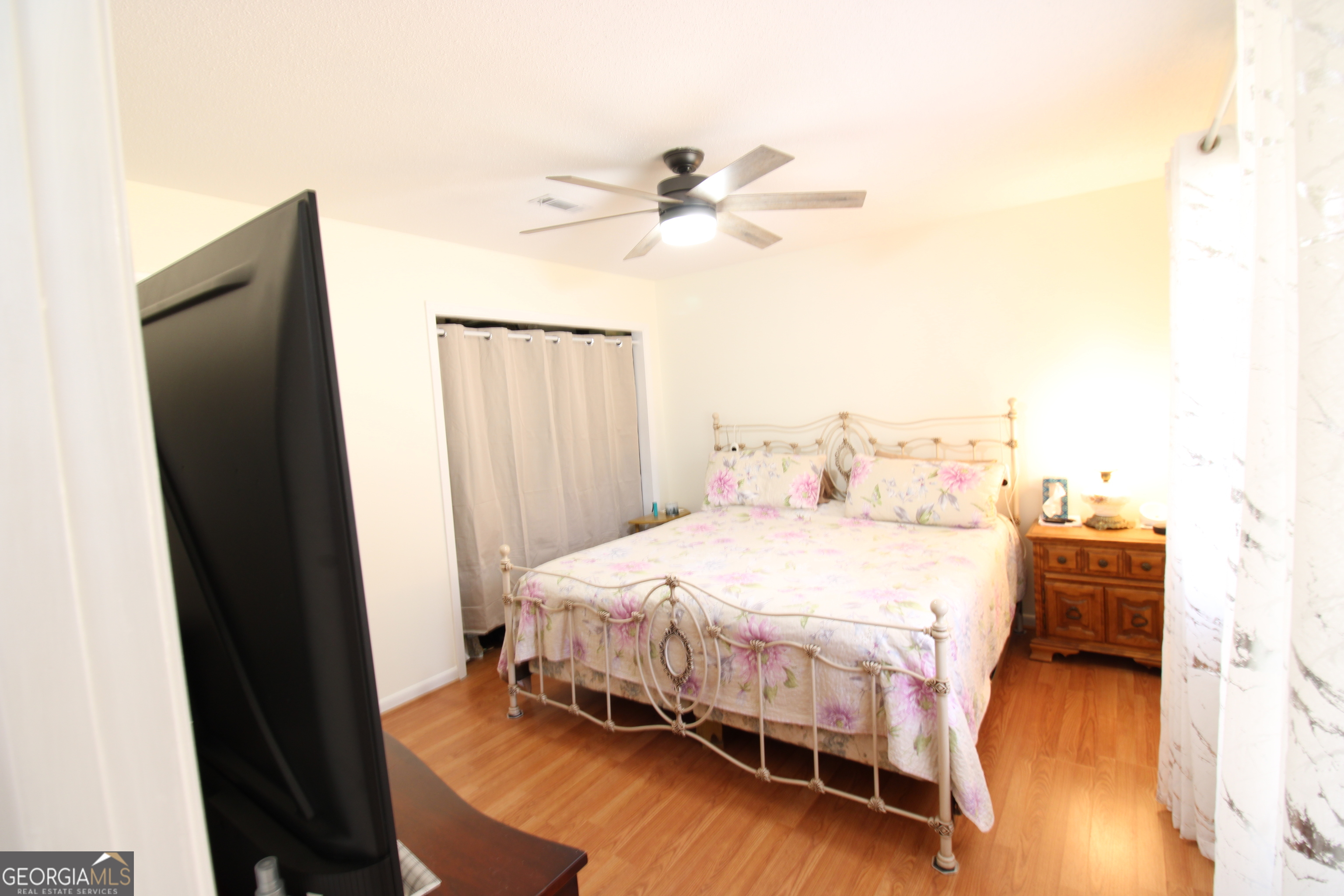 2337 Spring Street Waycross, GA 31503 - Photo 21 of 28 a bedroom with a bed and wooden floor