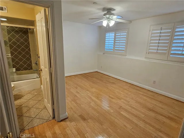 an empty room with windows and fan