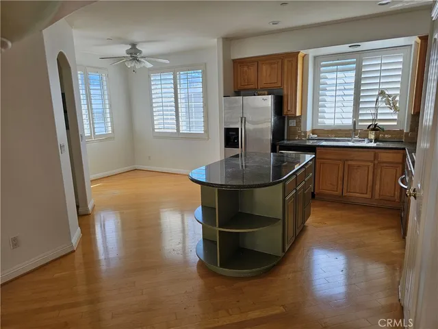 a kitchen with stainless steel appliances granite countertop a sink a stove and a wooden floors
