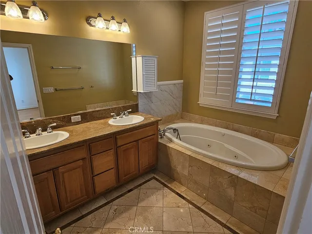 a bathroom with a tub sink and mirror