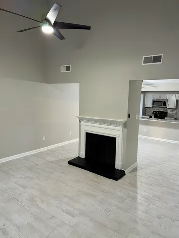 a view of a livingroom with a fireplace and a ceiling fan