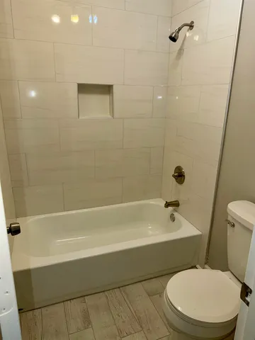 a white toilet and tub sitting next to a bathroom sink
