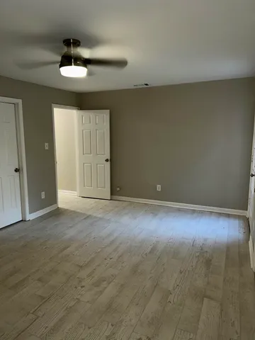 a view of an empty room with a chandelier fan