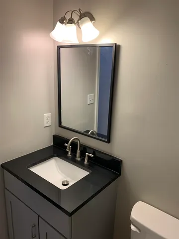 a bathroom with a toilet sink and mirror