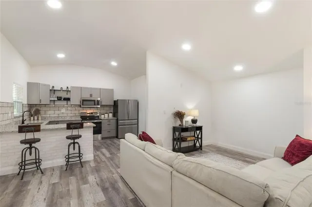 a living room with furniture and kitchen view