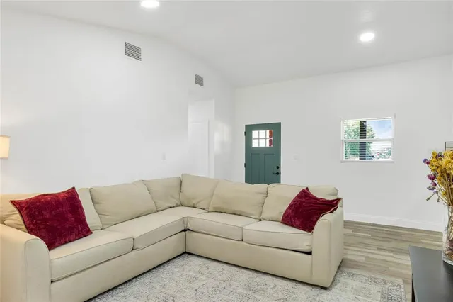 a living room with a couches and a potted plant on a dresser