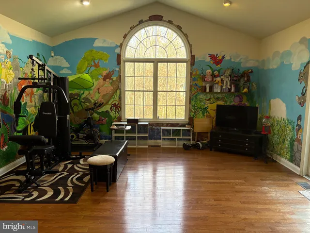 a living room with furniture gym equipment and a view of kitchen