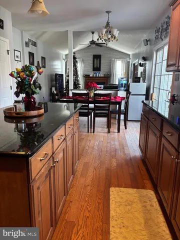a kitchen with stainless steel appliances a dining table wooden floor and a chandelier