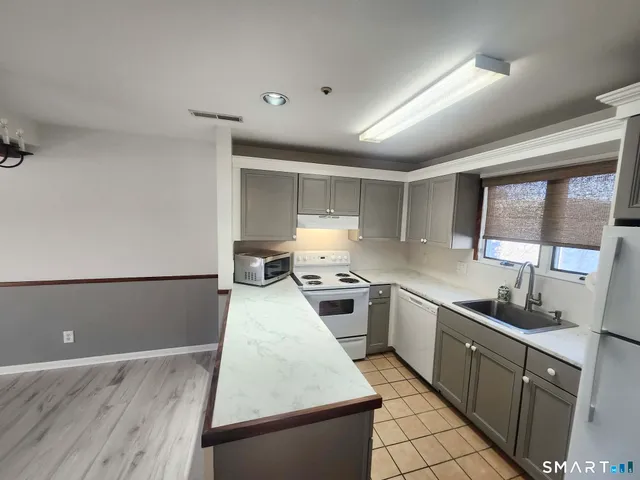 a kitchen with sink a stove and cabinets